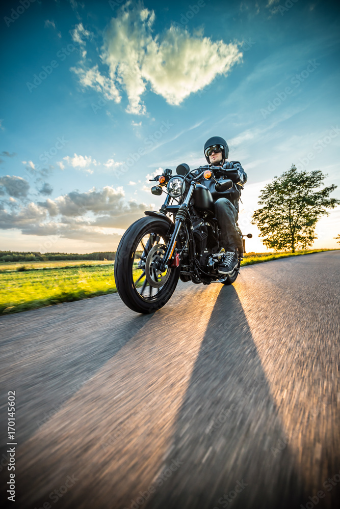 Fototapeta premium Mężczyzna jedzie sportster motocykl podczas zmierzchu.
