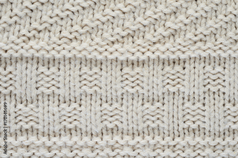 The texture of a knitted sweater is a thick beige string. Part of a sweater with various kinds of patterns close-up The texture of a knitted sweater is a thick beige string. Part of a sweater with various kinds of patterns close-up