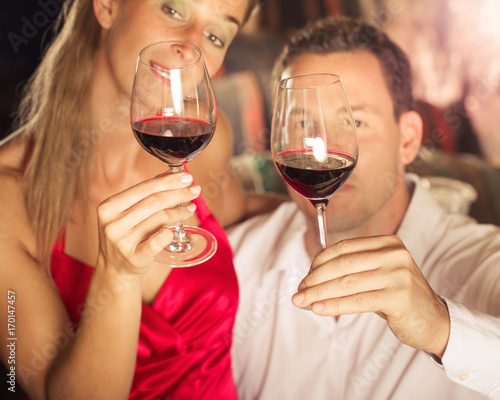 Paar kostet Rotwein bei Weinprobe im Weinkeller und prüfen den Wein optisch
