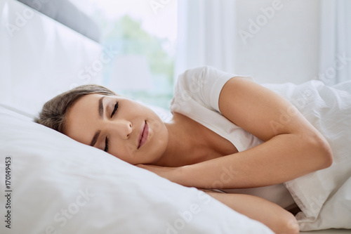 Portrait of beautiful young woman sleeping in bedroom