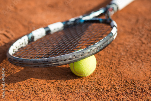 Close up view of tennis racket and balls on the clay tennis court, recreational sport © Khaligo