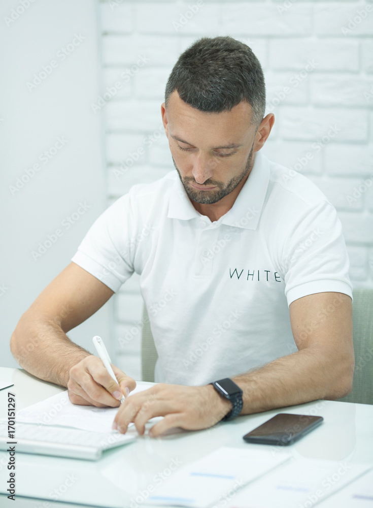 Business man sitting at white table on white background Business man sitting at white table on white background