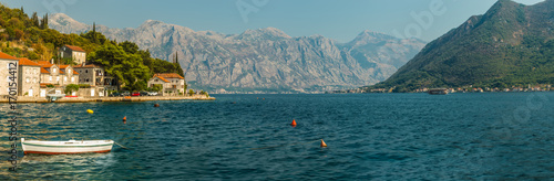 Panorama of Boka-Kotorsky Bay with a fragment of the embankment of the ancient city of Perast, Montenegro. A view of the mountains from the waters of the Bay of Kotor on the Adriatic Sea.