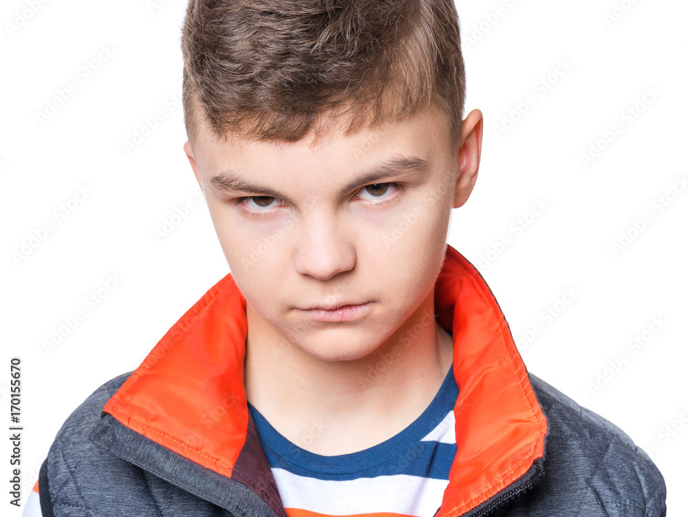 Teen boy making silly grimace - expressing disgust face. Upset child isolated on white background. Emotional portrait of caucasian teenager looking at camera. Teen boy making silly grimace - expressing disgust face. Upset child isolated on white background. Emotional portrait of caucasian teenager looking at camera.