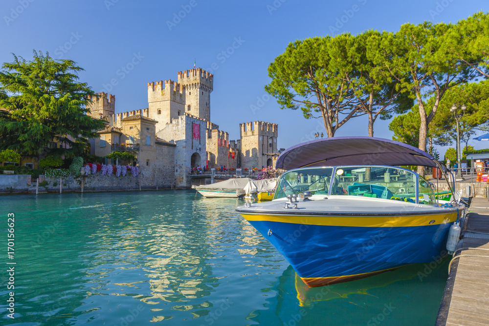 Motorboot im Hafen von Sirmione vor dem Castello Scaligero am Gardasee, Brescia, Lombardei, Italien