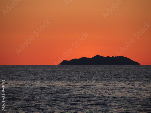 Beautiful sea sunset with island silhouette panorama . View of Gorgona island from Livorno city . Tuscany  Italy