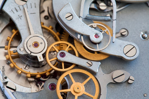 Clock transmission macro view. Stopwatch chronometer mechanism cogs gears wheels connection concept. Shallow depth of field, selective focus.