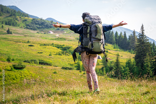 Woman-traveler freedom, standing with arms raised and enjoying the beautiful nature, Horizontal frame