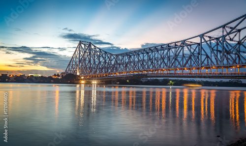 Historic Howrah bridge Kolkata at sunset with moody sky.