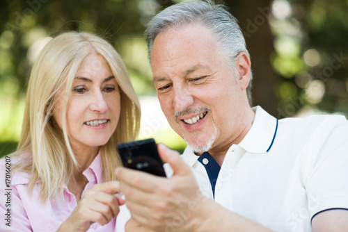 Happy mature couple using a cellphone