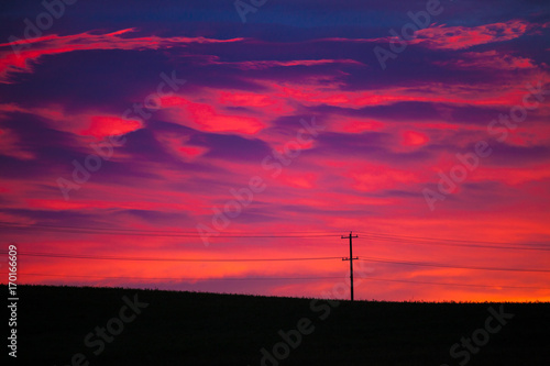 Colorful sky at sunrise with telephone pole and line