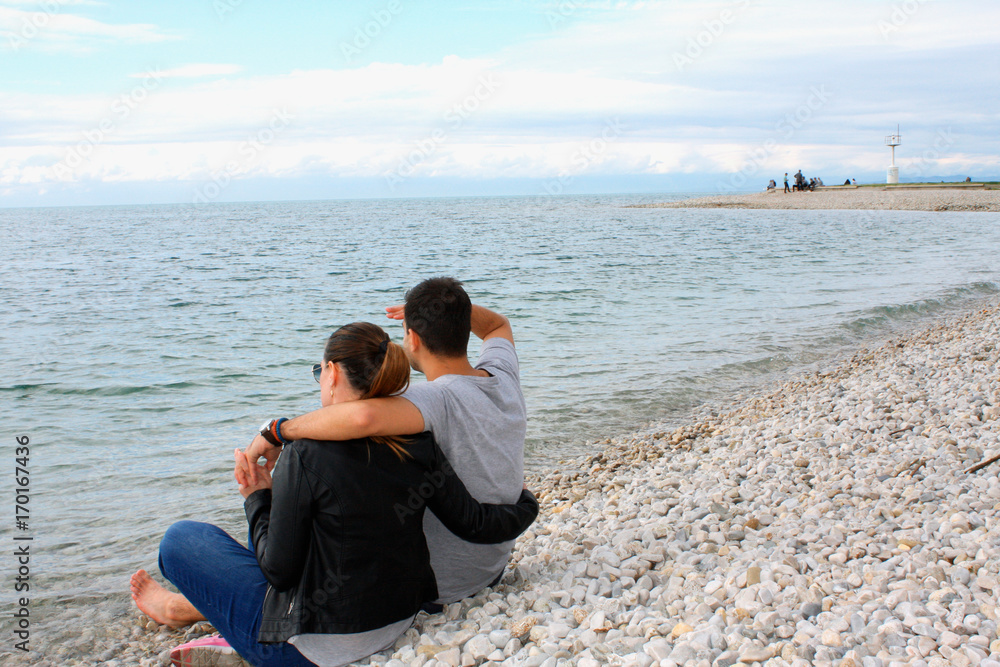 Back view of a romantic couple at beach during summer vacation