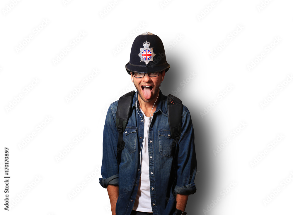 Young man in a helmet of the British policeman stick out his tongue Young man in a helmet of the British policeman stick out his tongue