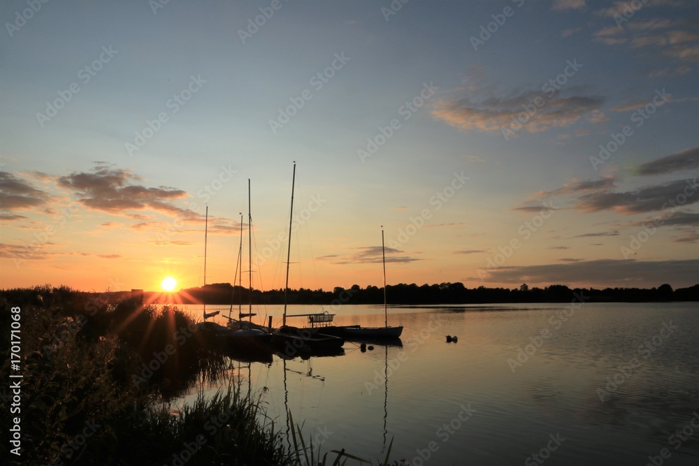 malerischer Sonnenuntergang am See mit Booten