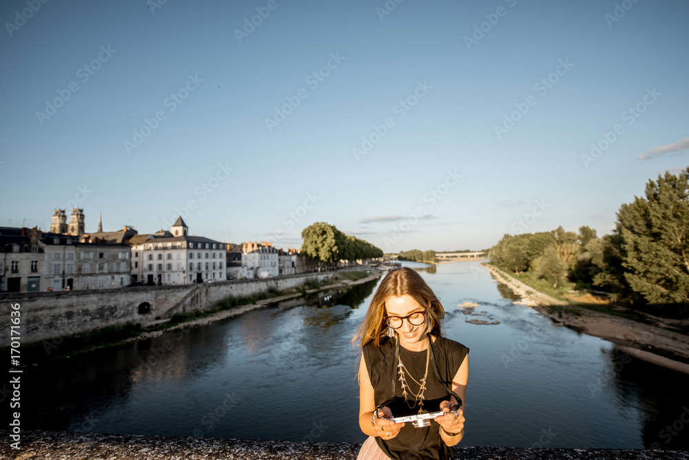 Young woman tourist standing on the bridge with beautiful cityscape view in Orleans, France