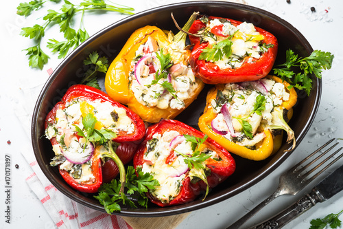 Stuffed paprika peppers with cheese and herbs. Top view on white.