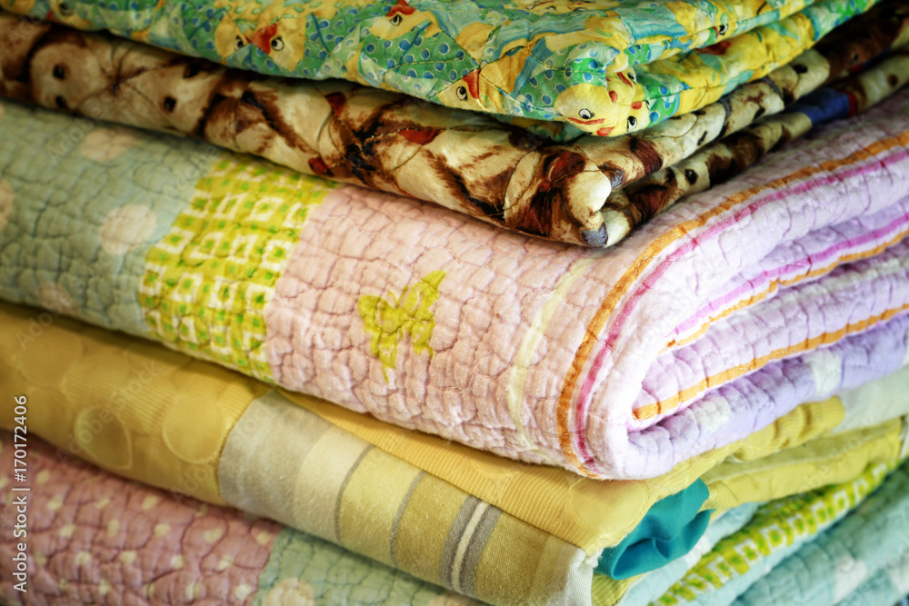 Stock of colorful old washed blankets folded after laundry.