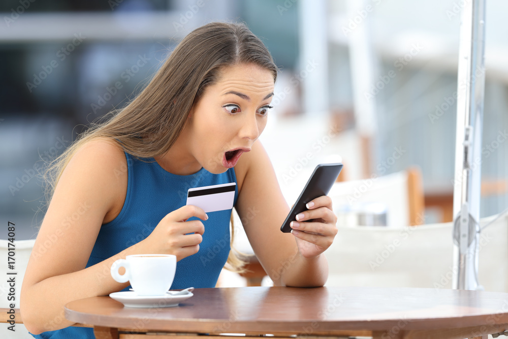 Astonished buyer finding offer on line in a bar Astonished buyer finding offer on line in a bar