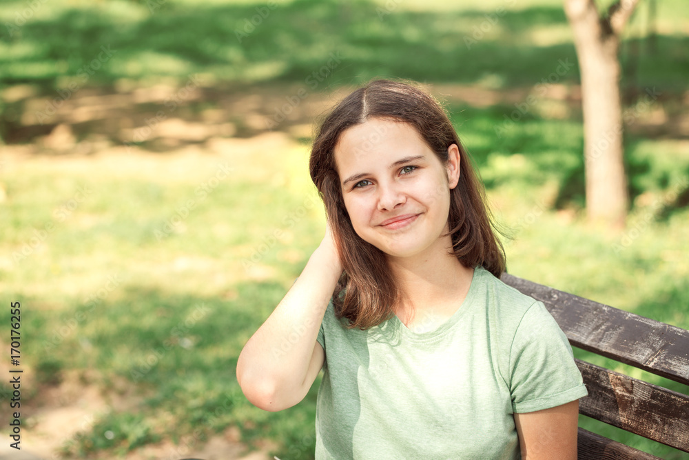 Young teenage girl in the park looking at the camera, close-up. Young teenage girl in the park looking at the camera, close-up.