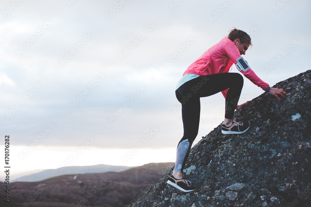 Athletic girl doing sports exercises in the mountains. Sport tight clothes. Intentional motion blur.