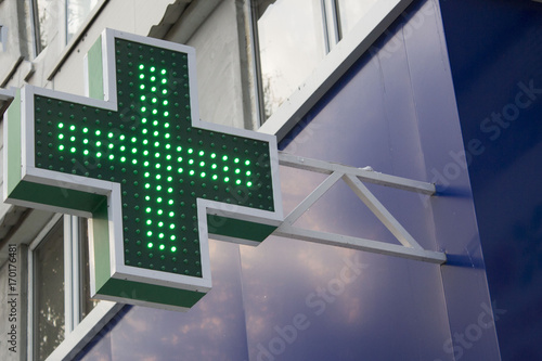 Pharmacy Neon Sign. Green сross sign on the building. Pharmacy concept. Drug store.
