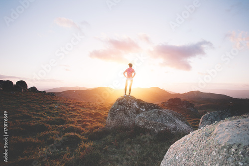 Sports girl examines mountain landscape for training on running at sunset. Sport tight clothes. 