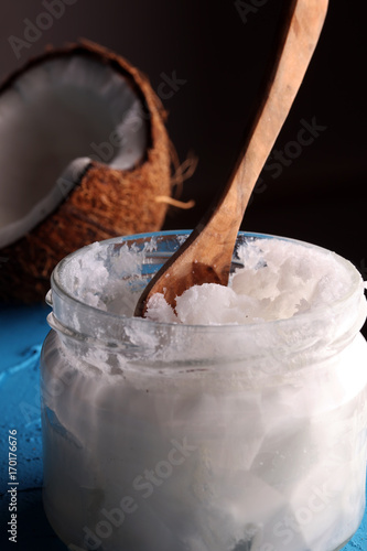 coconut oil and fresh coconuts on blue background