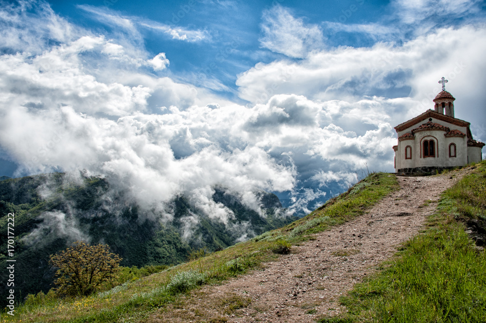 white clouds over a small church in the mountains white clouds over a small church in the mountains