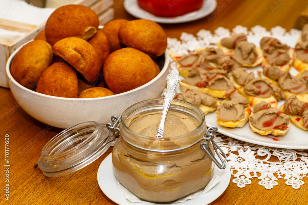 The chicken liver pate in a glass jar is on the table. The chicken liver pate in a glass jar is on the table.