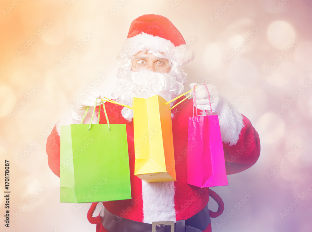 Funny Santa Claus have a fun with shopping bags on blue background Funny Santa Claus have a fun with shopping bags on blue background