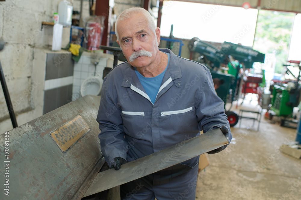 mature metal worker standing in workshop mature metal worker standing in workshop