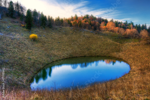 Cheshe Lake on Chernogor mountain plateau in Caucasus Mountains. Scenic autumn blue sky sunset landscape photo