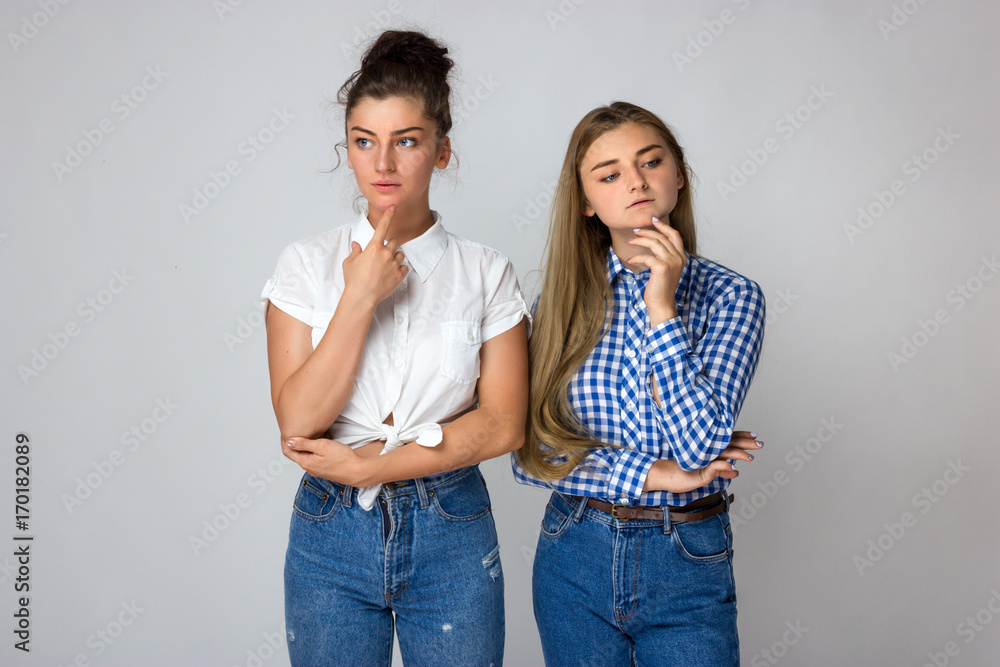 Naklejka premium Two young sisters thinks