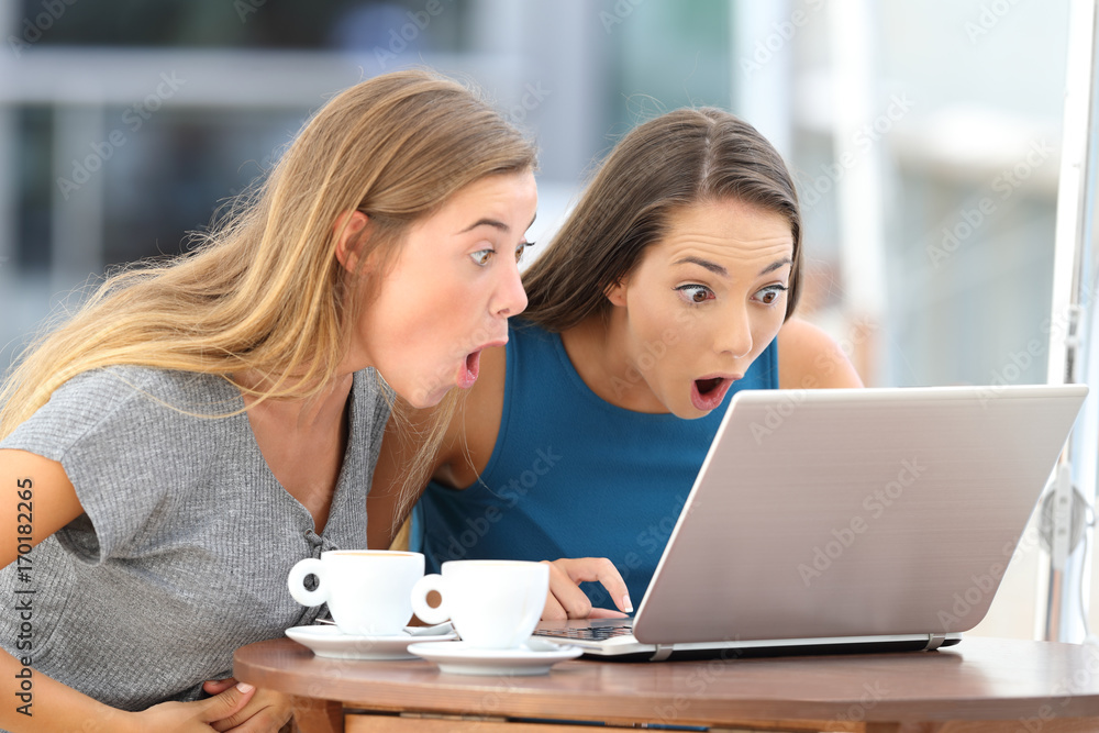 Amazed friends watching scandalous content in a bar Amazed friends watching scandalous content in a bar