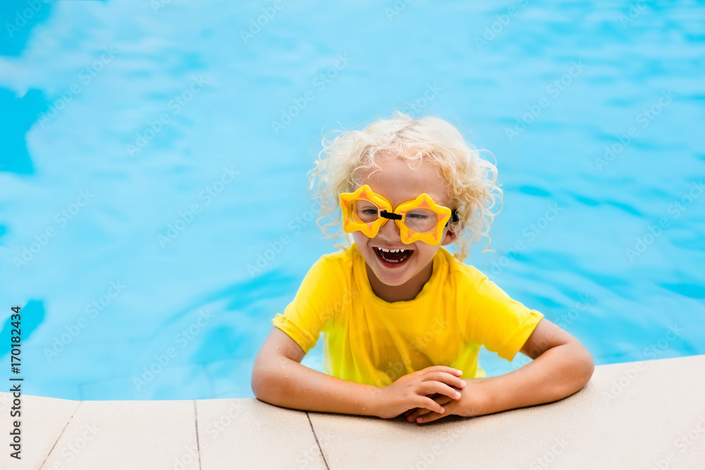 Naklejka premium Child with goggles in swimming pool. Kids swim.
