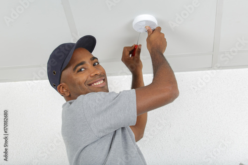 фотографія electrician removing battery from smoke detector