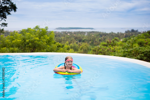 Child with goggles in swimming pool. Kids swim. © famveldman