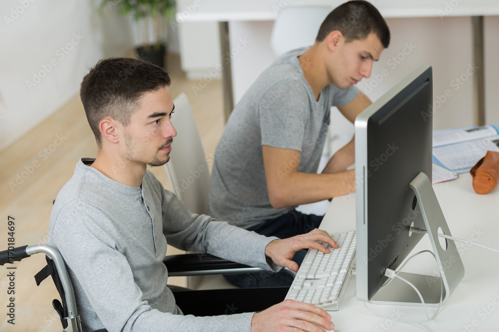 disabled young man in wheelchair doing homework disabled young man in wheelchair doing homework