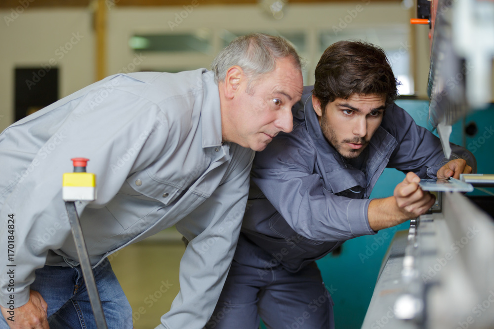 Obraz premium metal craftsman teaching know-how to young man