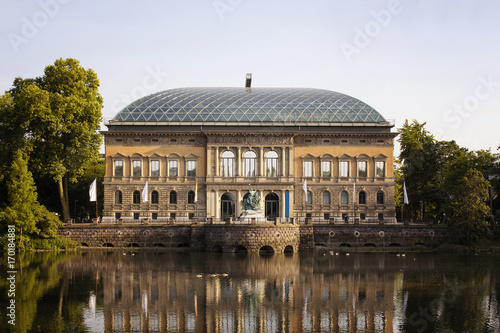 View of a modern art museum (K21, Kunstsammlung Nordrhein-Westfalen) in Dusseldorf. Lake and trees is also in view.