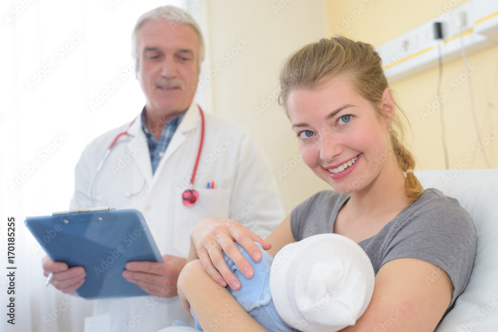 Fototapeta premium doctor and smiling woman holding baby