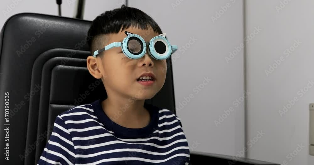 Young boy while undergoing eye test in optical shop