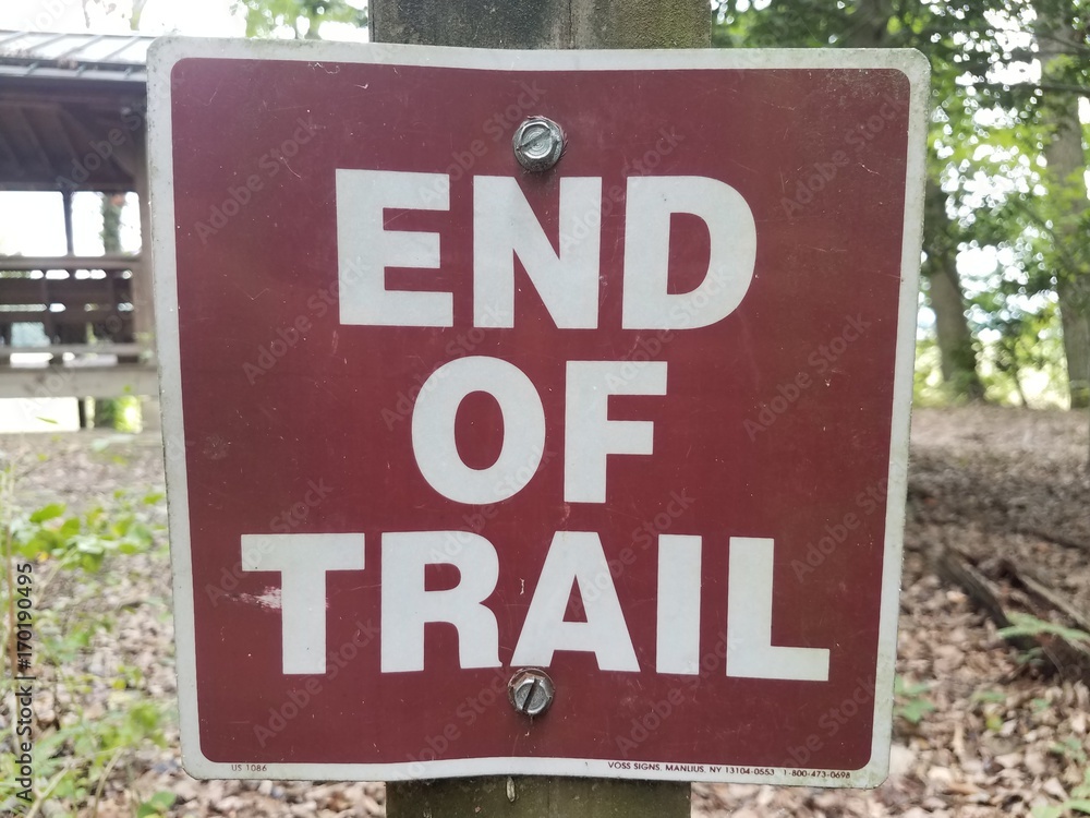brown and red end of trail sign