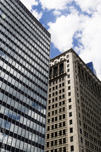 Older And Newer Skyscraper Buildings With Clouds And Blue Sky