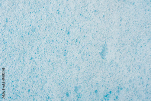 Foam bubble from soap or shampoo washing on blue background top view