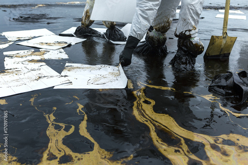 Photos Workers remove and clean up crude oil spilled with absorbent paper