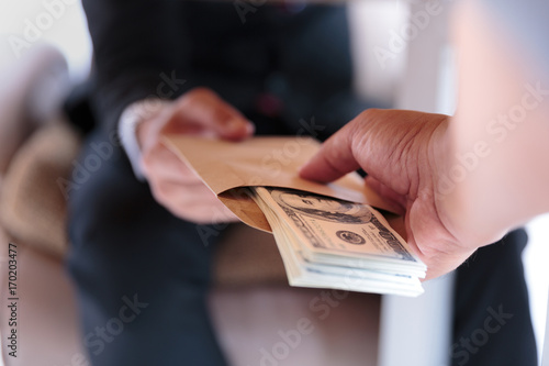 Businessman receive money under the table - anti bribery and corruption concepts photo