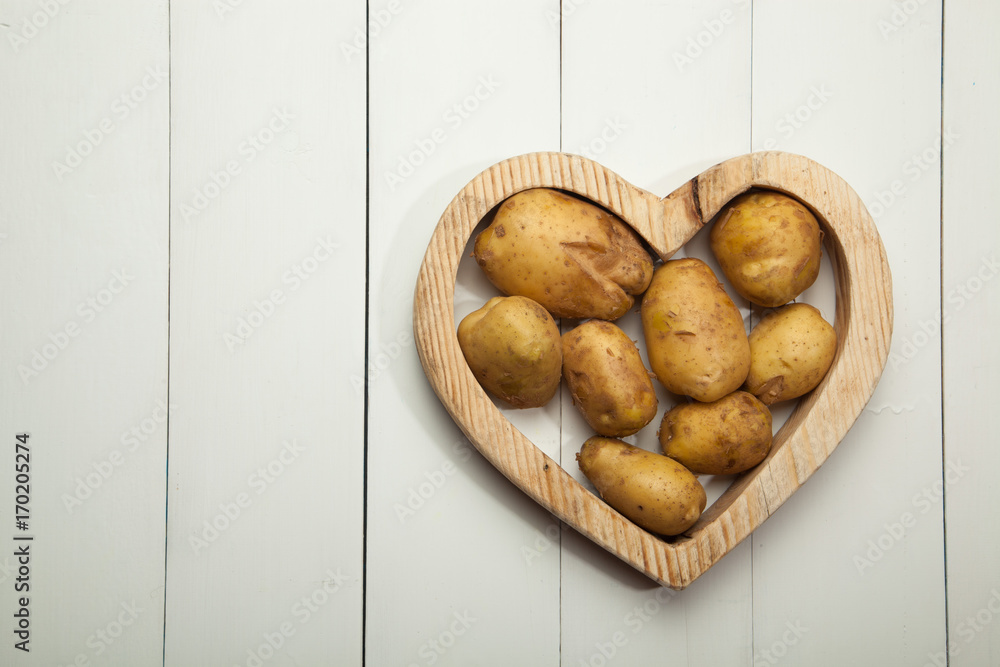 Raw potatoes on a white wooden background Raw potatoes on a white wooden background