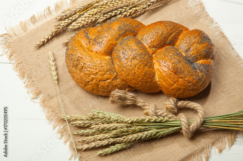 Wheat and traditional Russian bread on a white wooden background