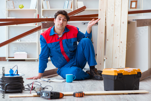 Young carpenter with notebook writing planning at construction r